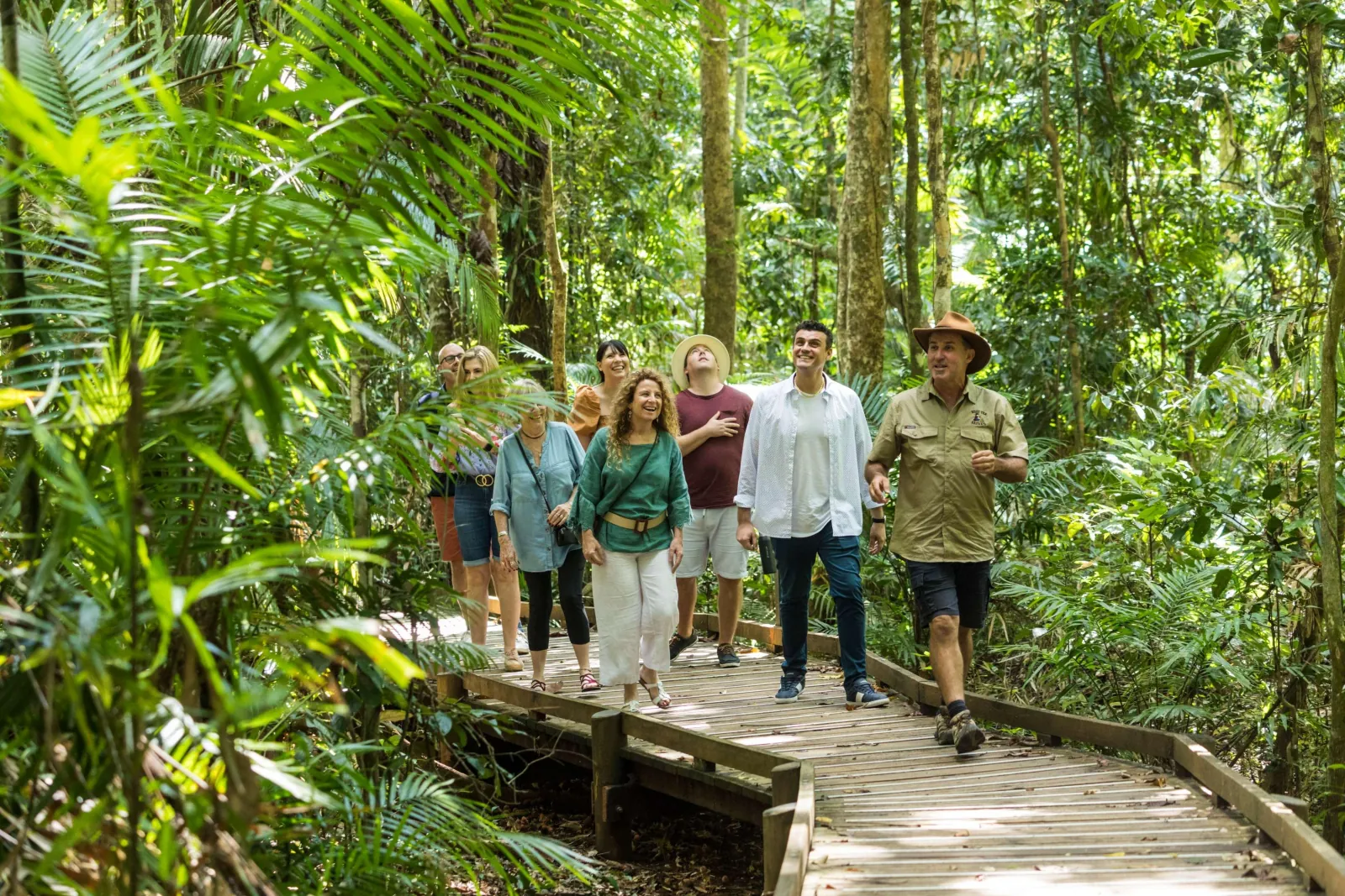 Tour group walking a rainforest boardwalk with their guide