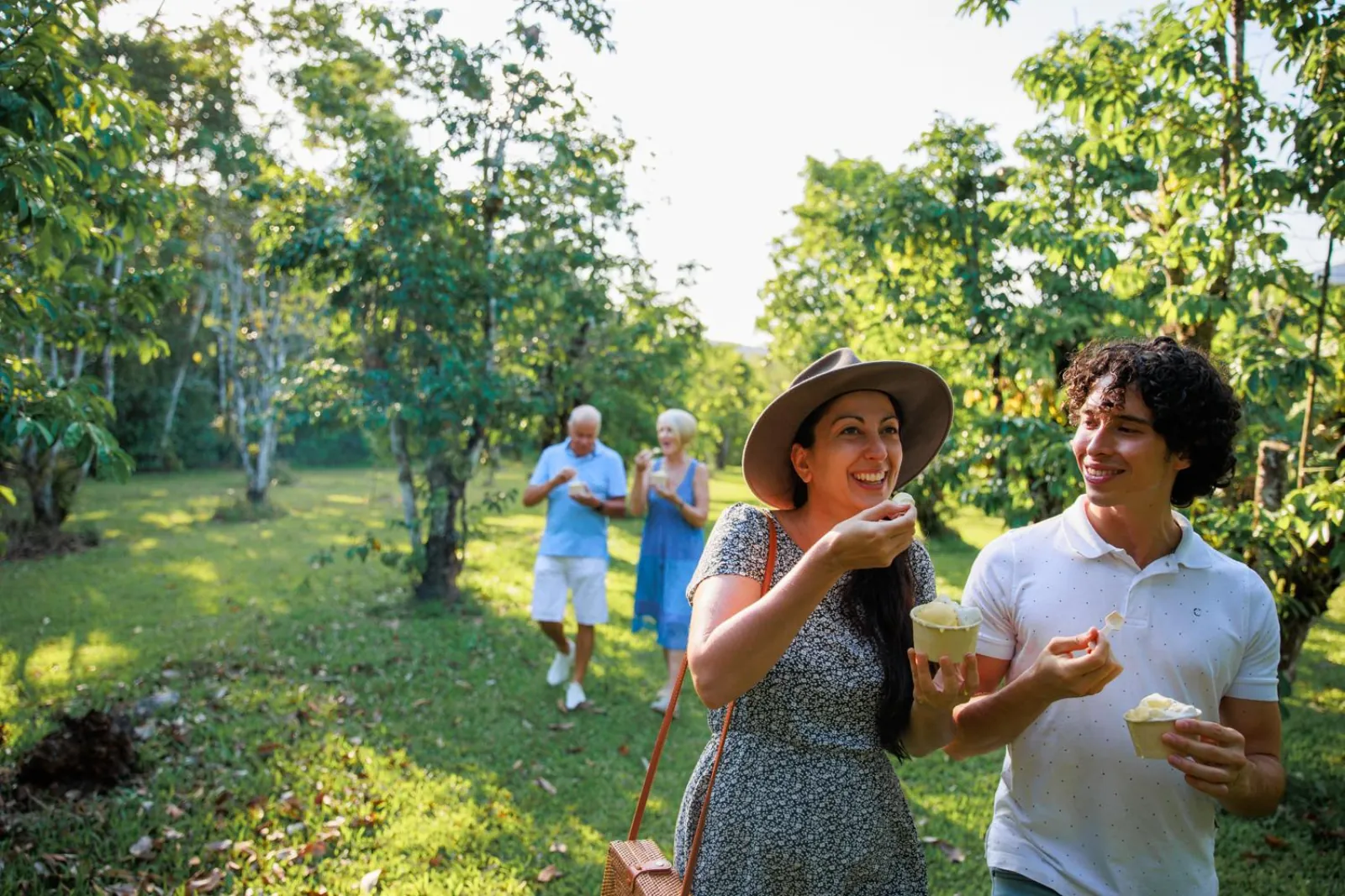 Guests tasting tropical fruit on a lawn beside the rainforest