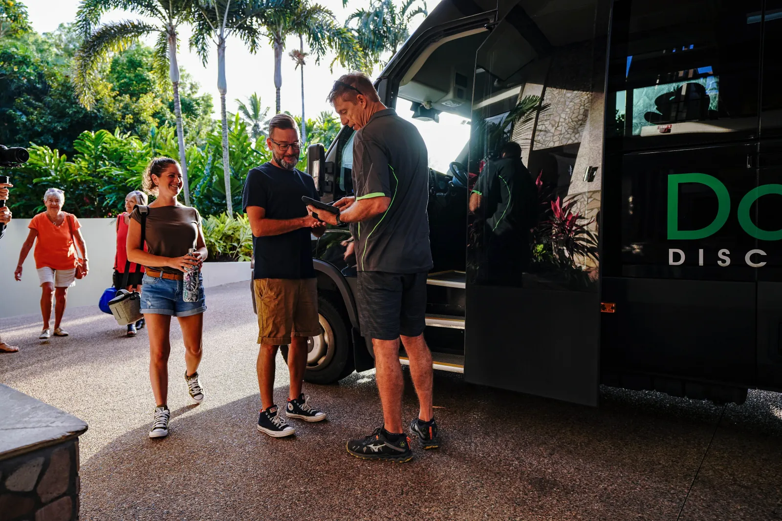 Guests beside a tour van at a Port Douglas pickup