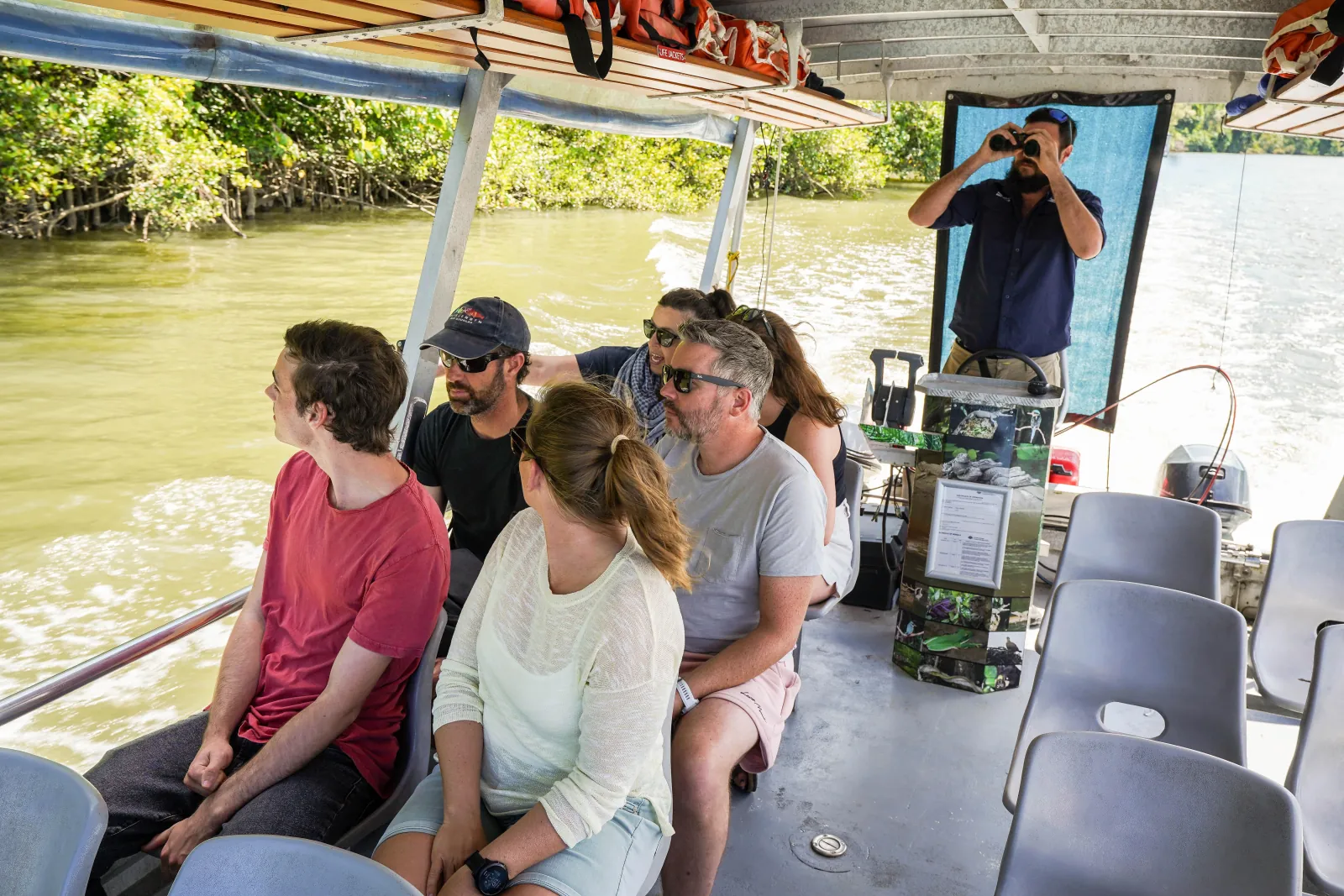 Passengers listening to the skipper on a Daintree River cruise