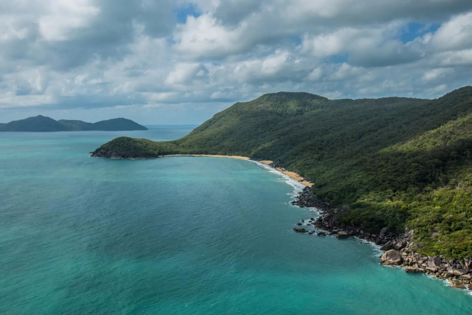Aerial view of a rainforest coast and turquoise bay